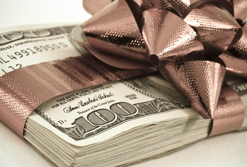 Money gift ideas for birthdays: bundle of bills with a brown ribbon