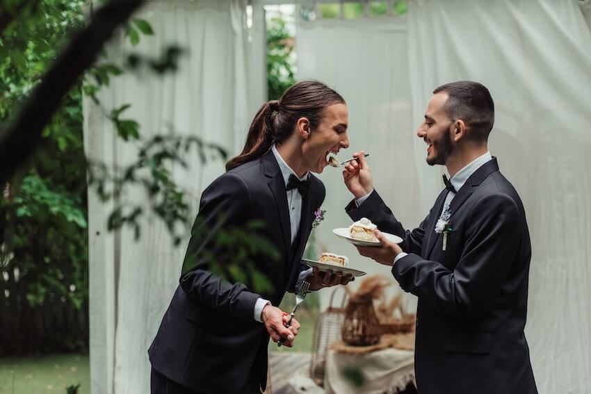 Groom feeding his spouse a piece of cake