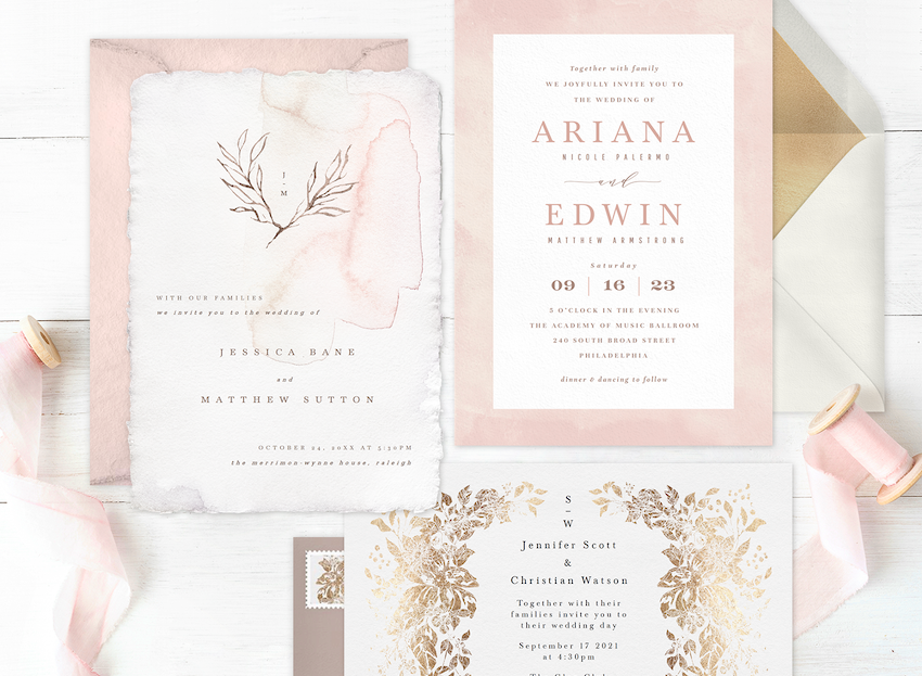 three affordable wedding invitations laid out on a wood table with ribbon and envelopes